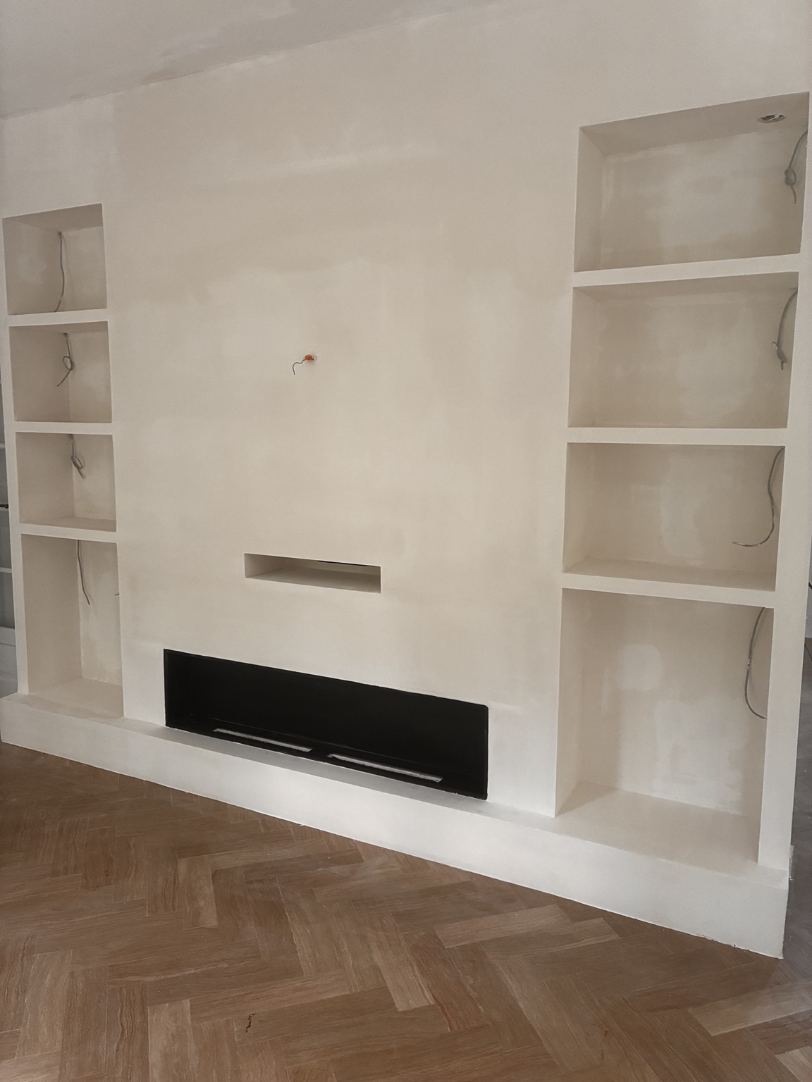Aménagement en plaques de plâtre avec niches, emplacement TV et poêle à éthanol encastré réalisé à Francueil